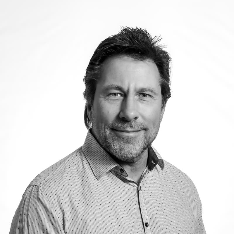 Black and white portrait of Neil Marshment, greying stubble, in a patterned shirt
