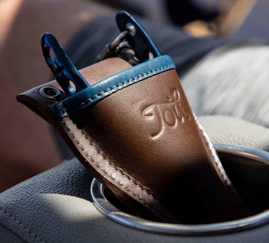 Embossed Toit leather tool holster sitting in a car cup holder