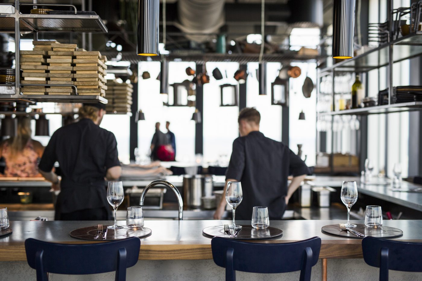 An open restaurant kitchen behind a set bar