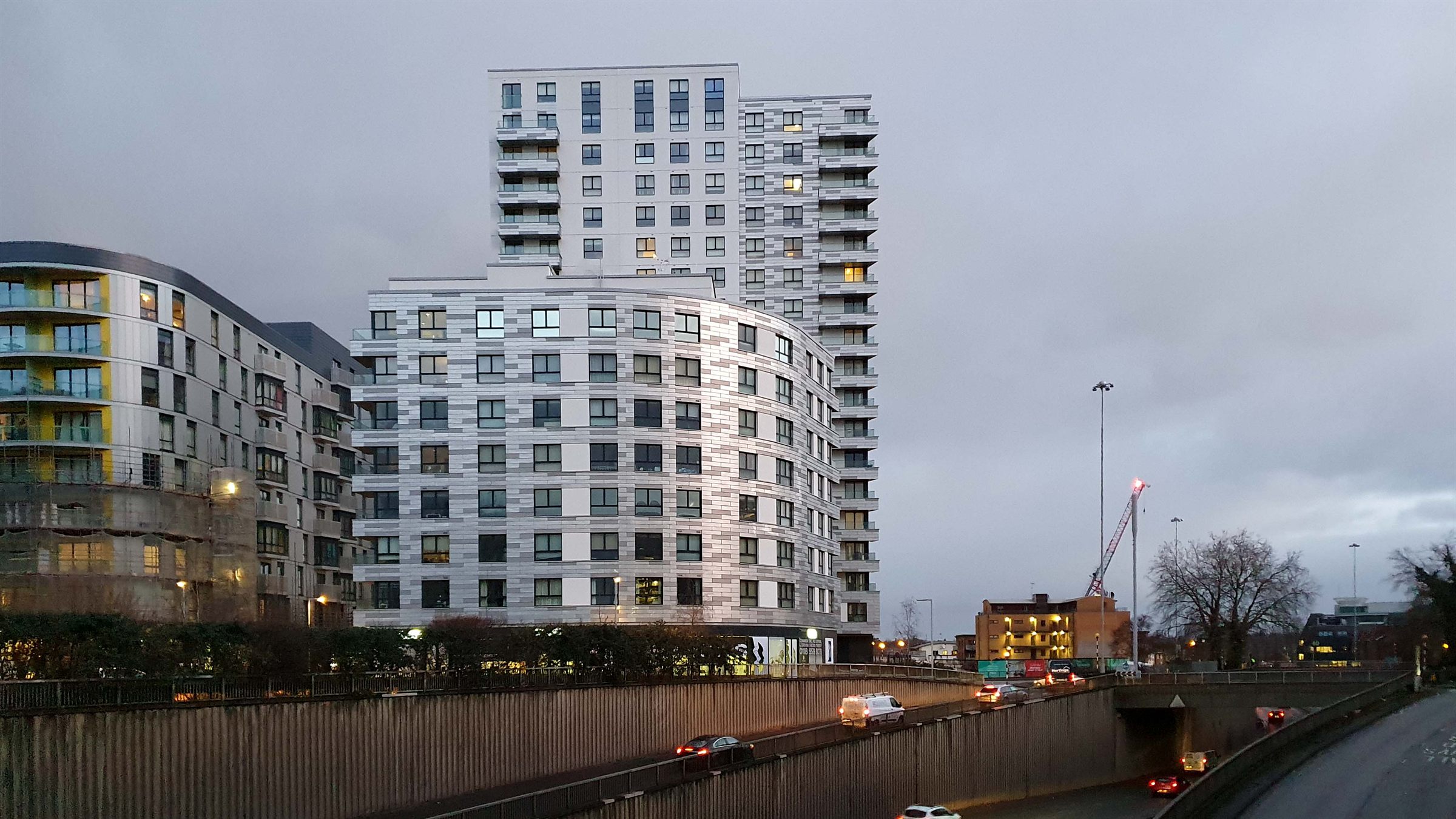 Reading at dusk, apartment towers rising over the traffic passing under the Inner Distribution Road