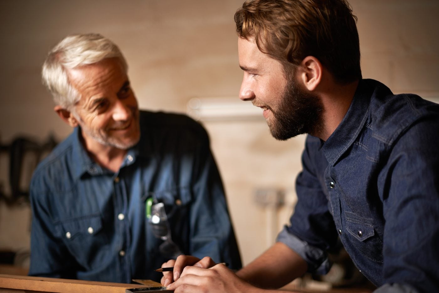 Two people talking over a workbench