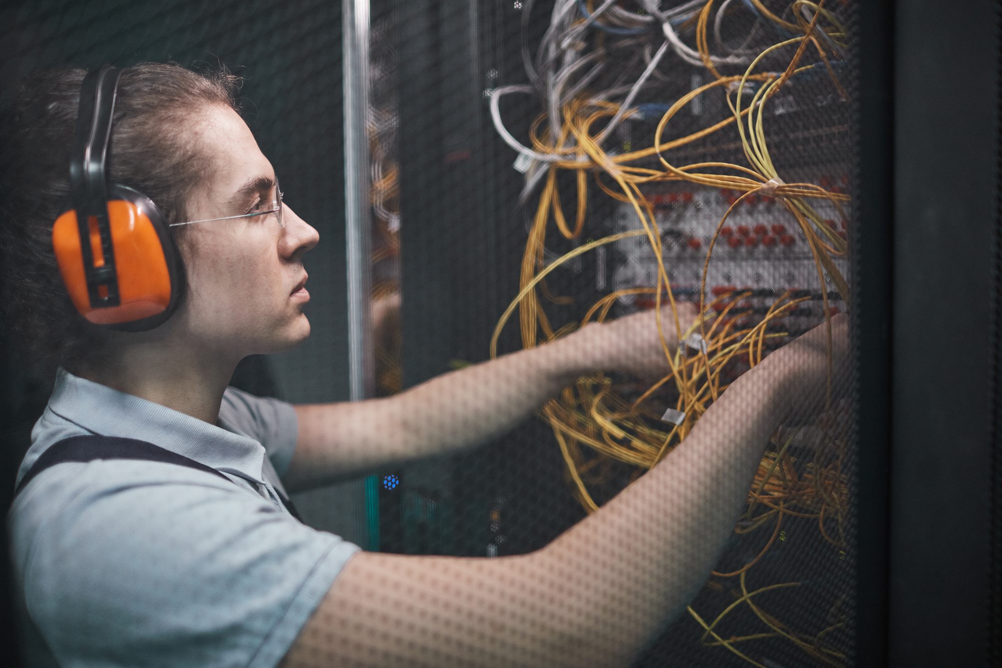 A technician working among server room cables