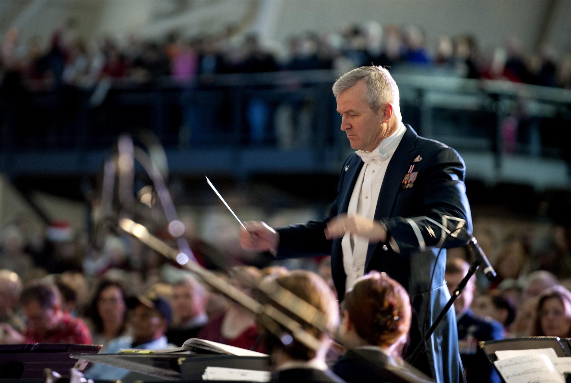 An orchestra conductor mid-rehearsal