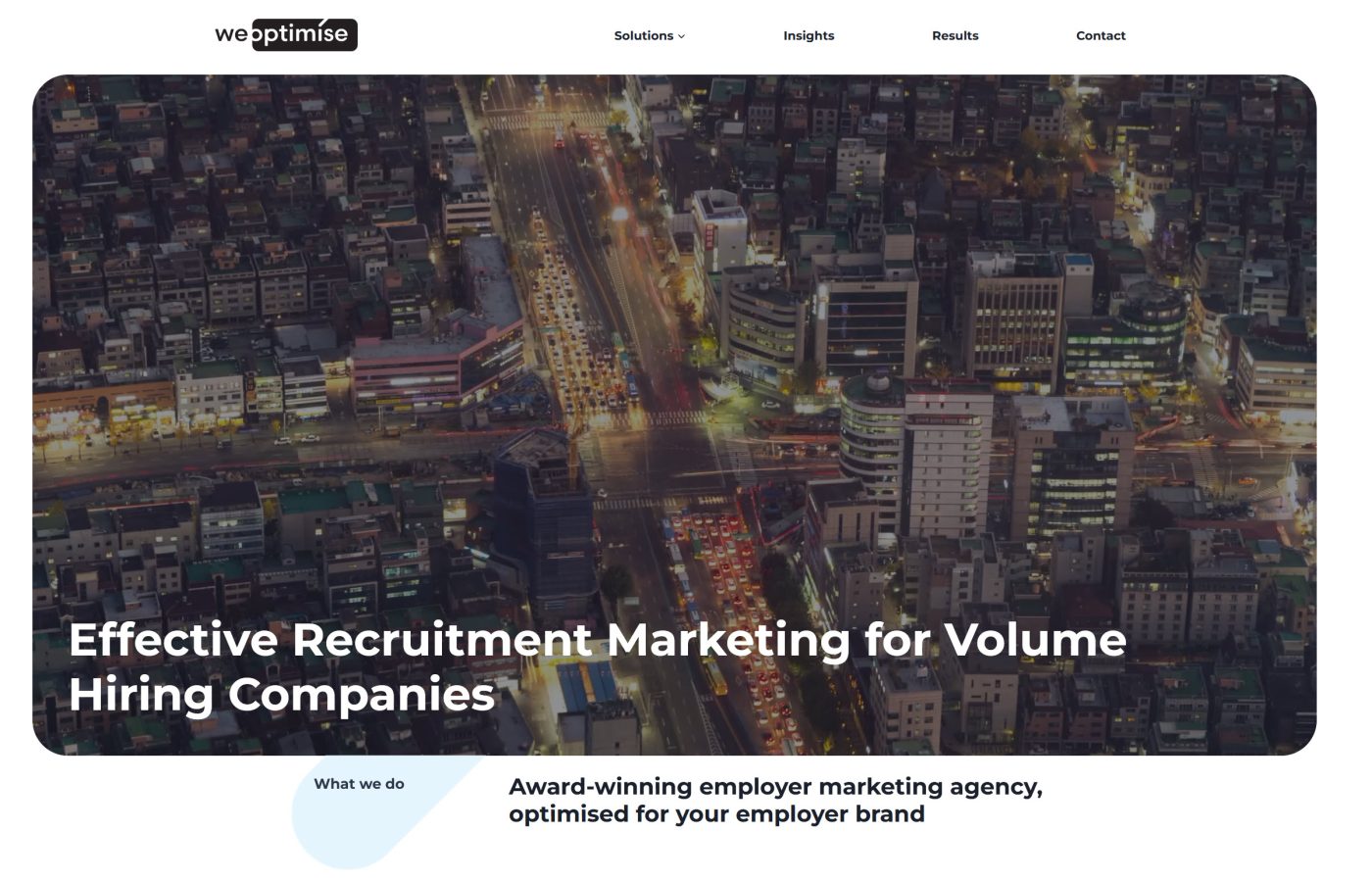 A WeOptimise landing page with a night-time aerial photograph behind the headline