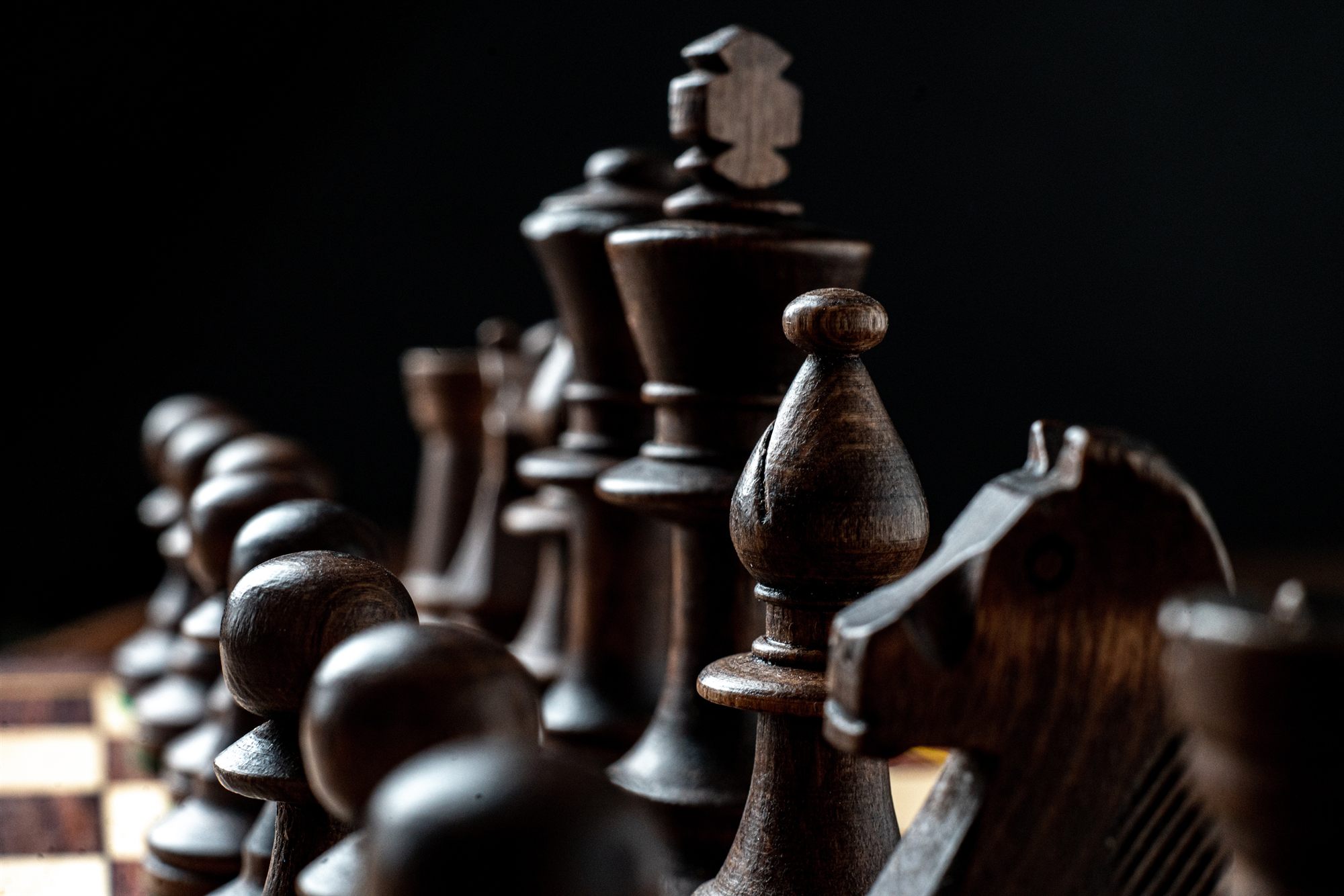 Dark wooden chess pieces on a board