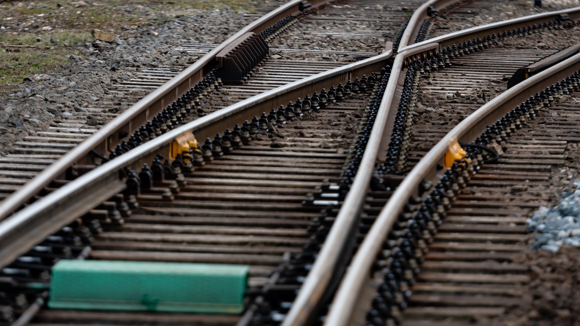 Railway tracks converging across gravel