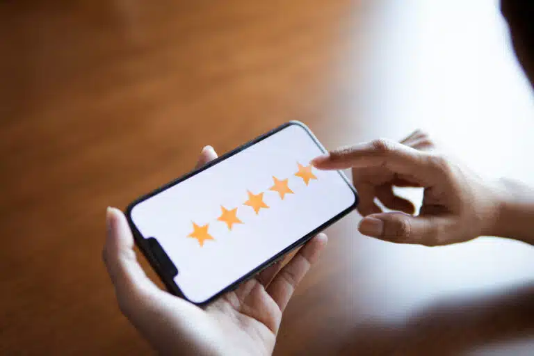 A customer tapping a five star rating on a smartphone screen