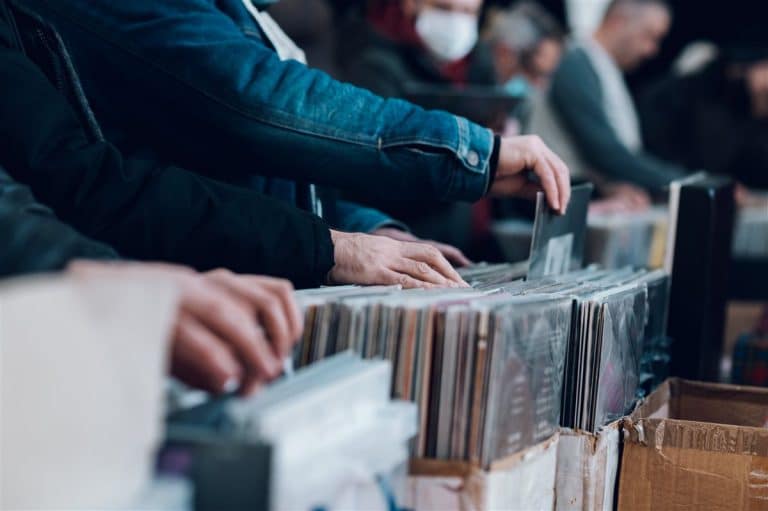 Shoppers flicking through crates of vinyl records at a market stall