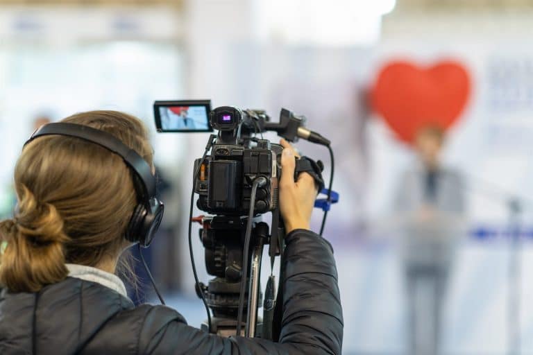 A camera operator filming a conference presentation