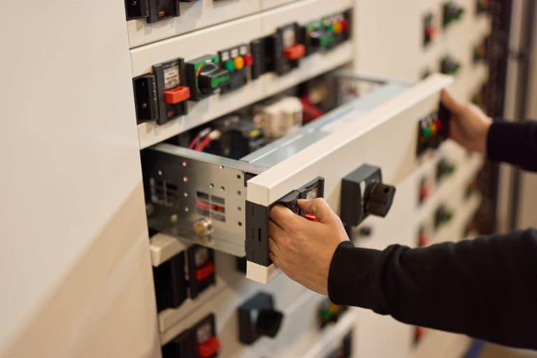 An electrical engineer working on a circuit breaker panel