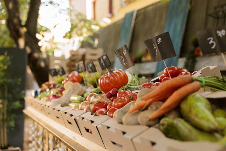 Local produce arranged on a farmers market stand