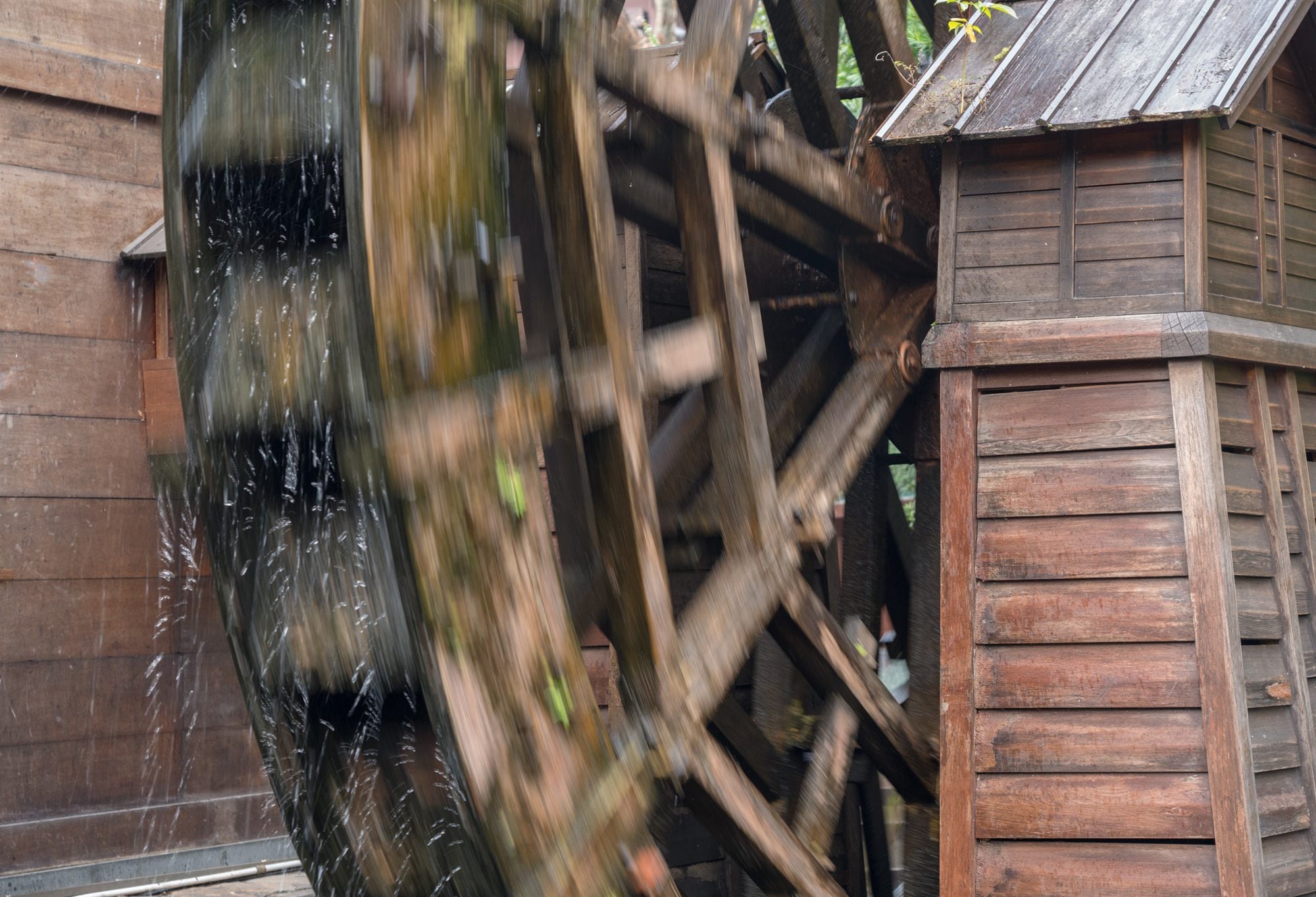 A wooden waterwheel turning under falling water