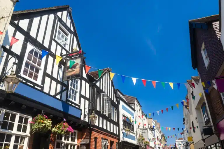 Bunting strung across a half-timbered high street under a blue sky